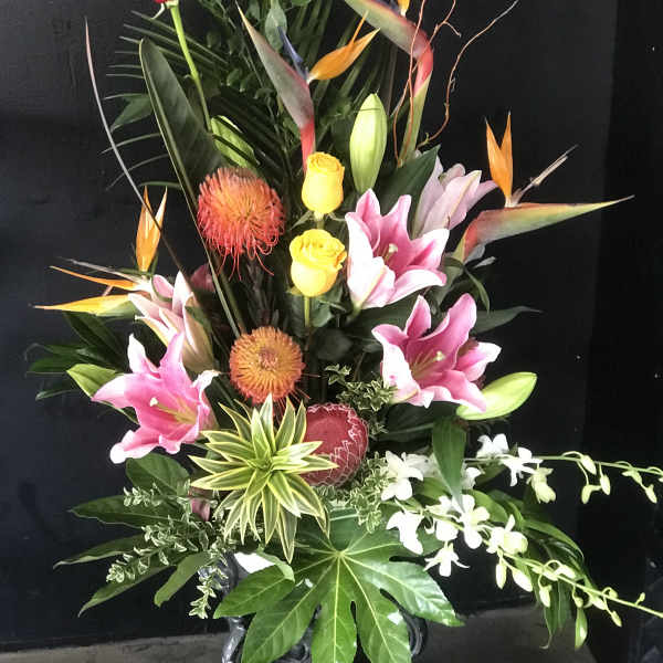 Tall tropical bouquet with pink lilies, red roses, and bird-of-paradise