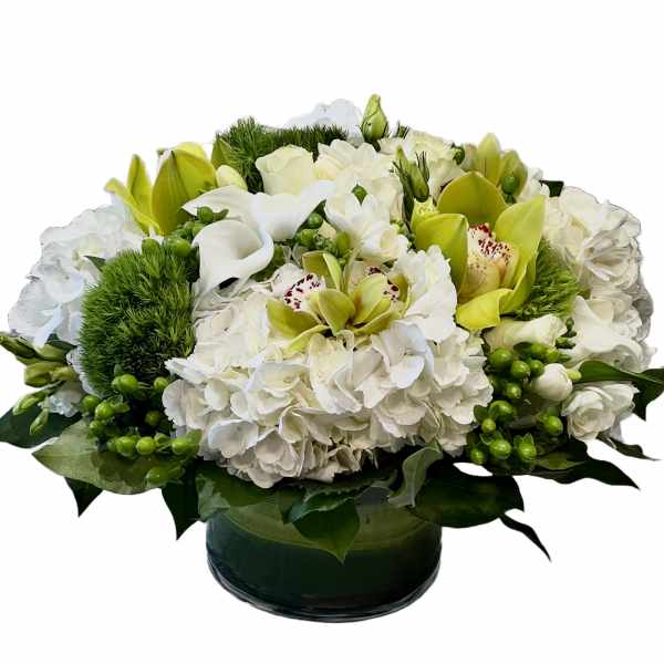 White and green floral arrangement in a low glass vase