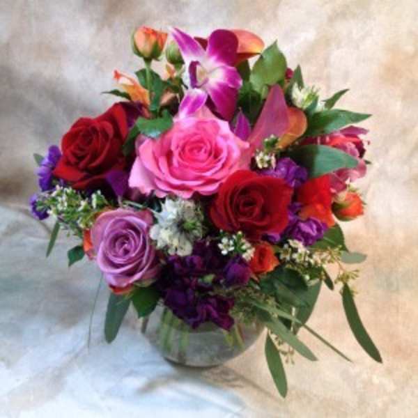 Mixed bouquet of roses and orchids in a glass vase