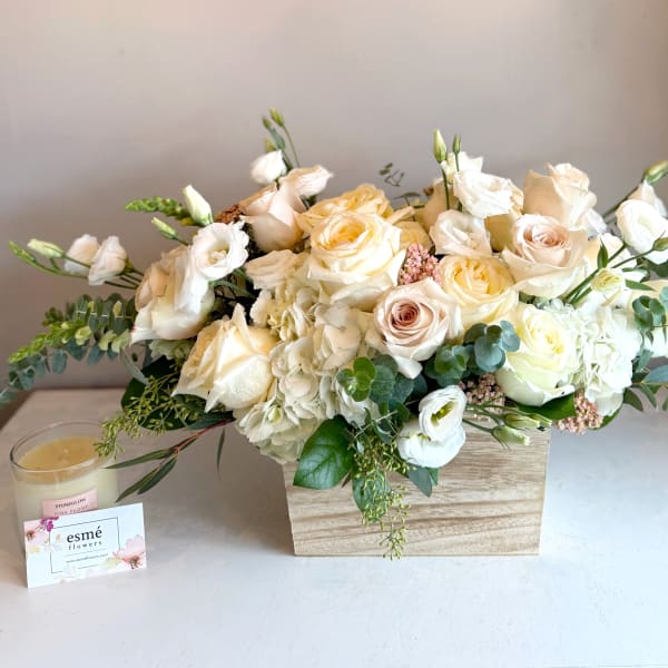 Cream and white rose arrangement in a wooden box with eucalyptus