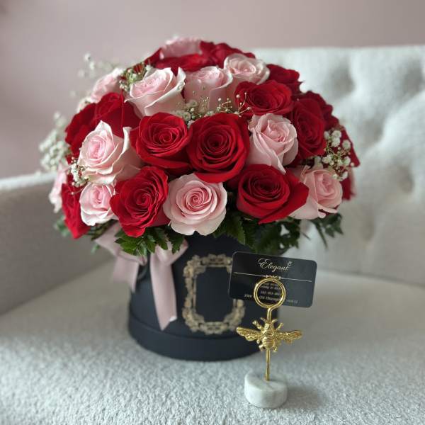 Bouquet of red and pale pink roses in a black hat box