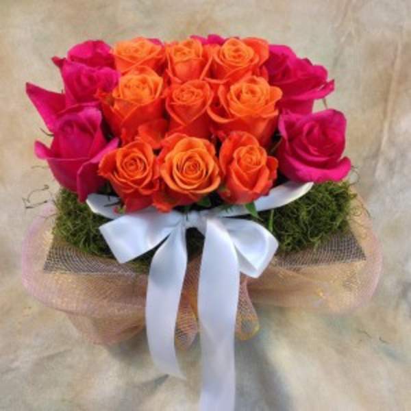 Bouquet of orange and hot pink roses with a white ribbon