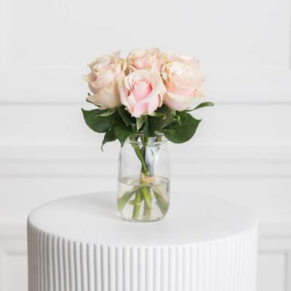 Blush pink roses in a clear glass vase