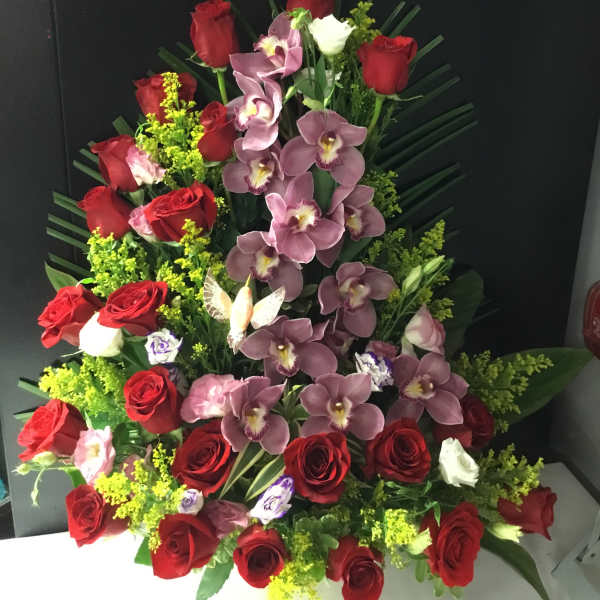 Tall arrangement of red roses and purple orchids