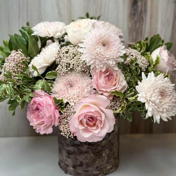 Pink and white roses with white chrysanthemums in a rustic vase