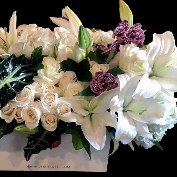 White lilies, roses, hydrangeas, and purple orchids in a white box