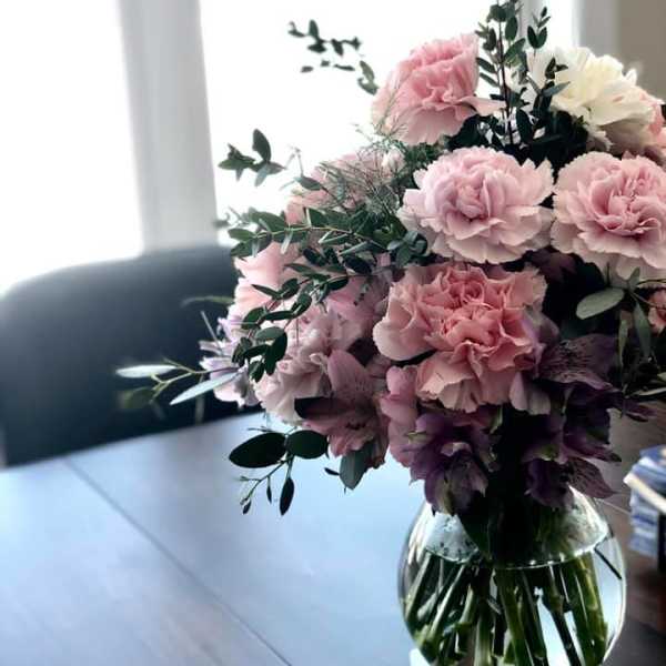 Pink and white carnations in a clear glass vase
