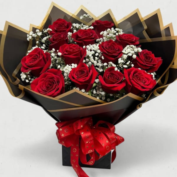 Bouquet of red roses with white baby's breath in black and gold wrapping