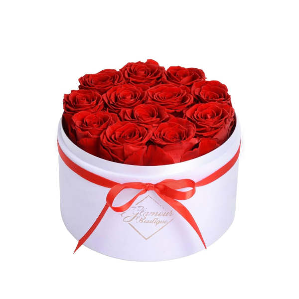 Red roses arranged in a white round box with a red ribbon