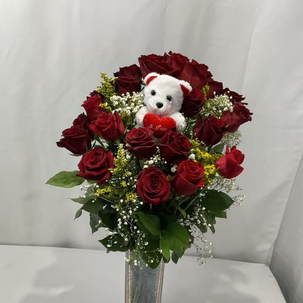 Red rose bouquet with a small teddy bear in a glass vase