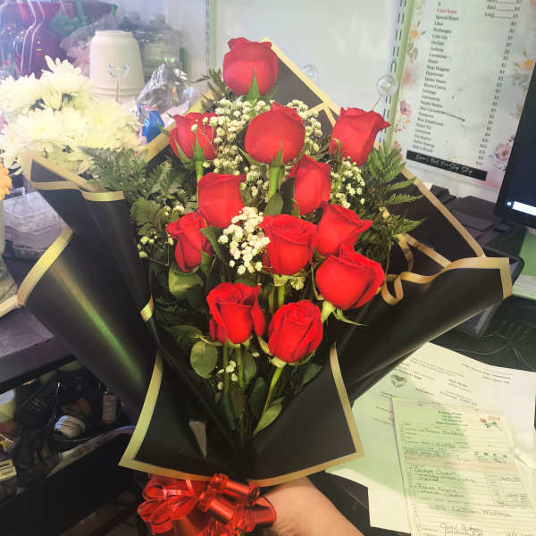 Bouquet of red roses with baby's breath in black wrap and red ribbon