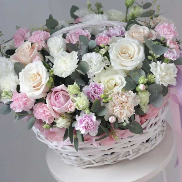 Pink and white roses with carnations in a white basket