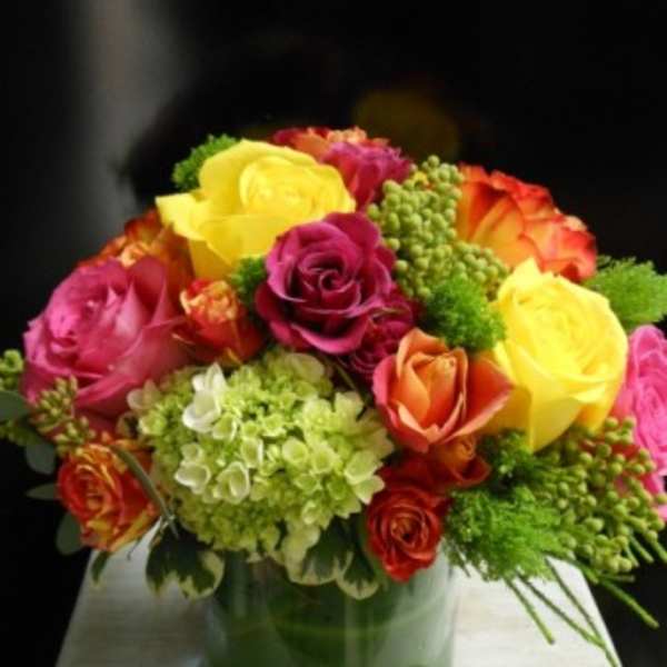 Colorful rose bouquet in a green glass vase