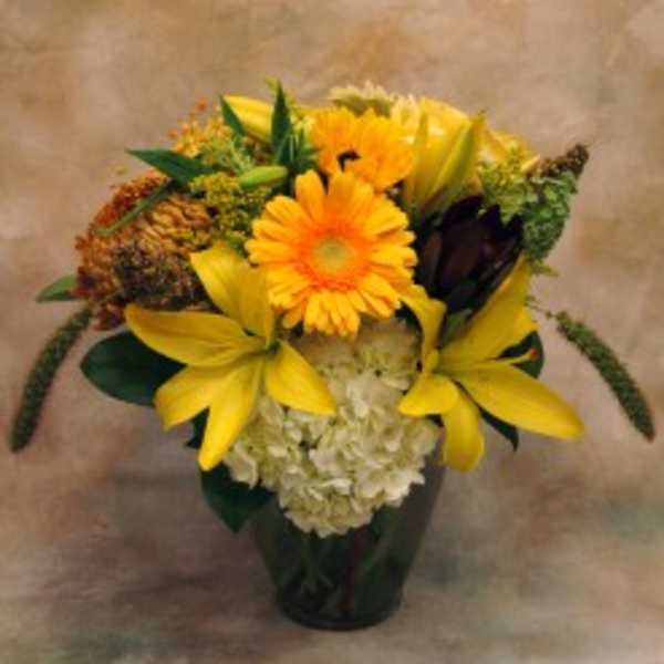 Yellow and orange flower arrangement in a dark vase