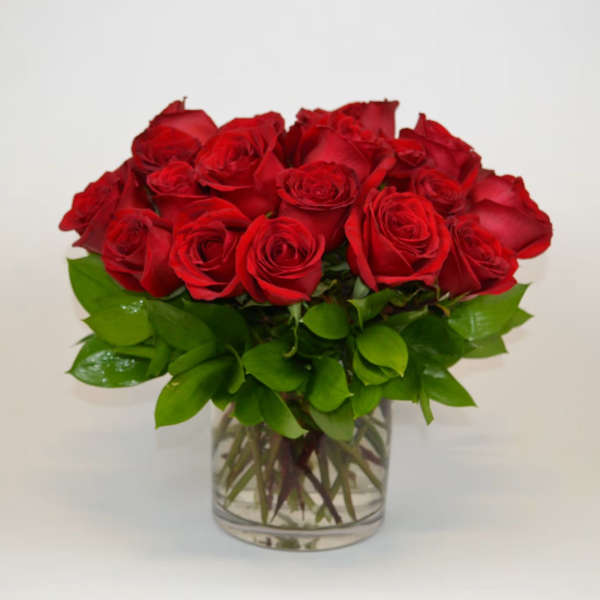 Red roses arranged in a clear glass vase
