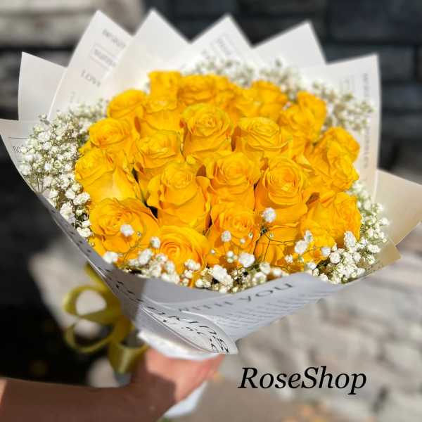 Bouquet of yellow roses with white baby's breath in white paper wrap