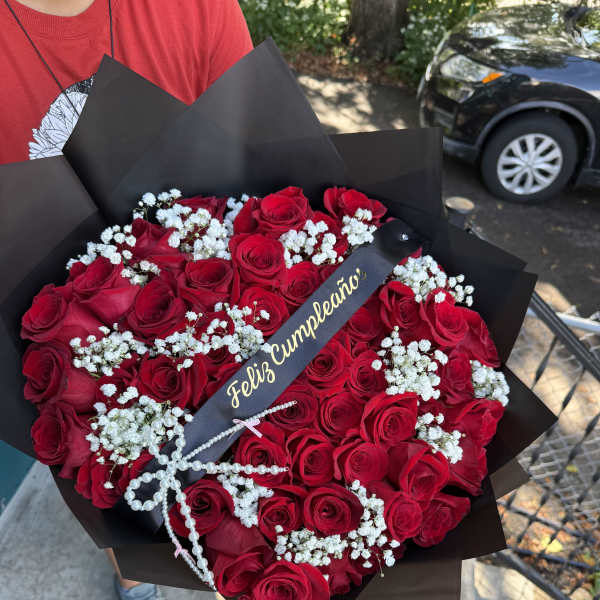 Bouquet of red roses with white baby's breath in black wrap