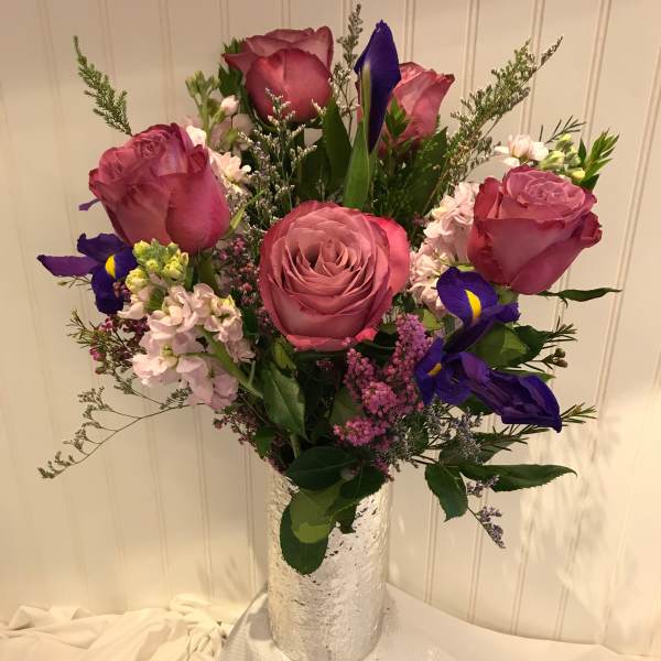 Pink roses and purple irises in a silver vase