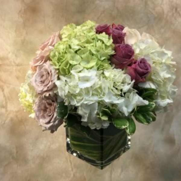 Bouquet of hydrangeas and roses in a square glass vase