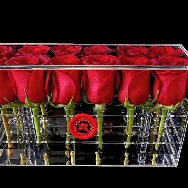 Red roses arranged in a clear rectangular acrylic box
