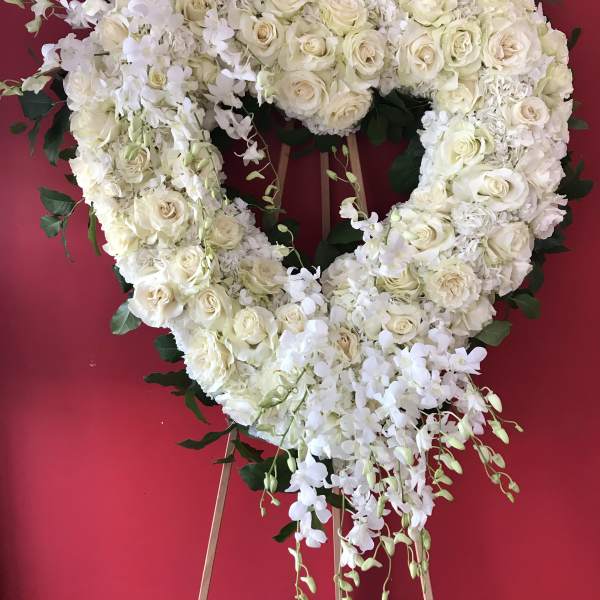 Heart-shaped white floral wreath on an easel