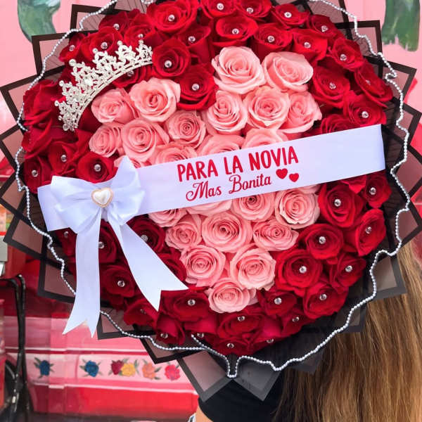 Heart-shaped bouquet of red and pink roses with a tiara and ribbon