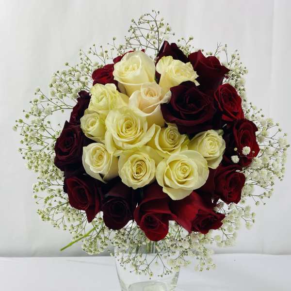 Bouquet of red and cream roses in a clear glass vase