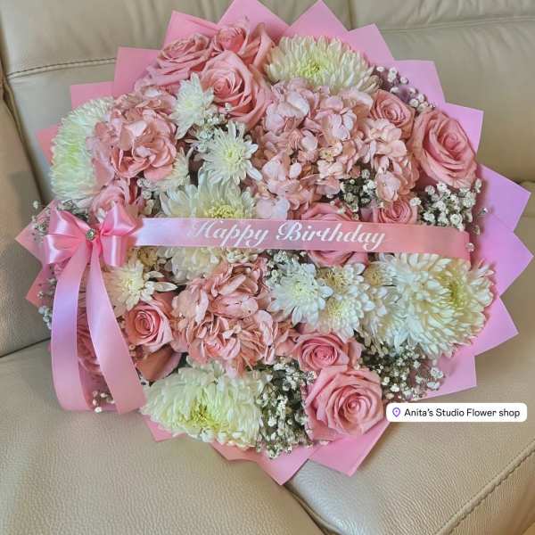 Pink bouquet of roses and white chrysanthemums with a birthday ribbon