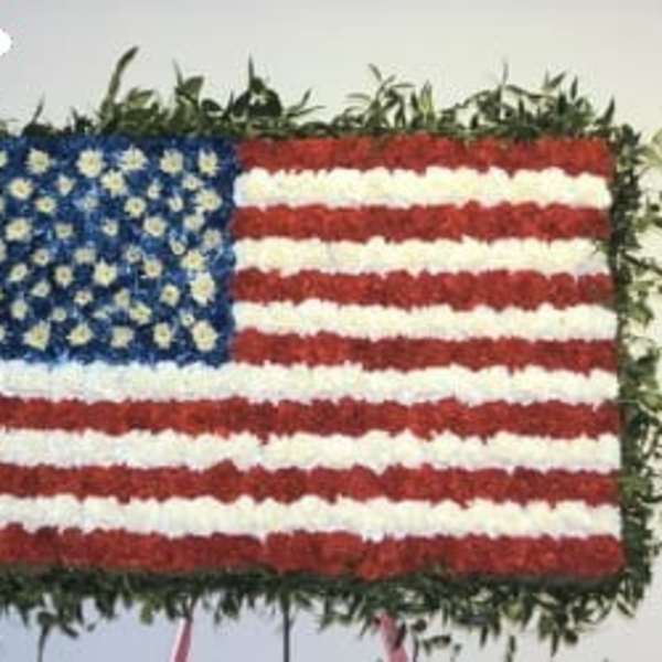 Floral arrangement shaped like the U.S. flag with red, white, and blue flowers