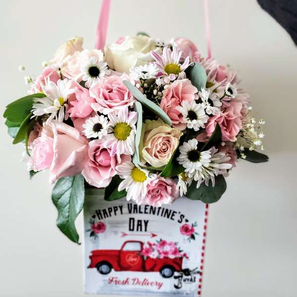 Pink and white mixed flower bouquet in a gift bag
