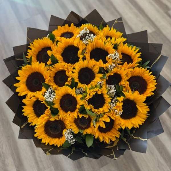 Bouquet of sunflowers wrapped in dark paper