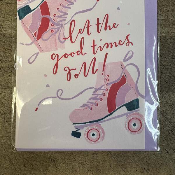 Greeting card with pink roller skates and the words let the good times roll in red script