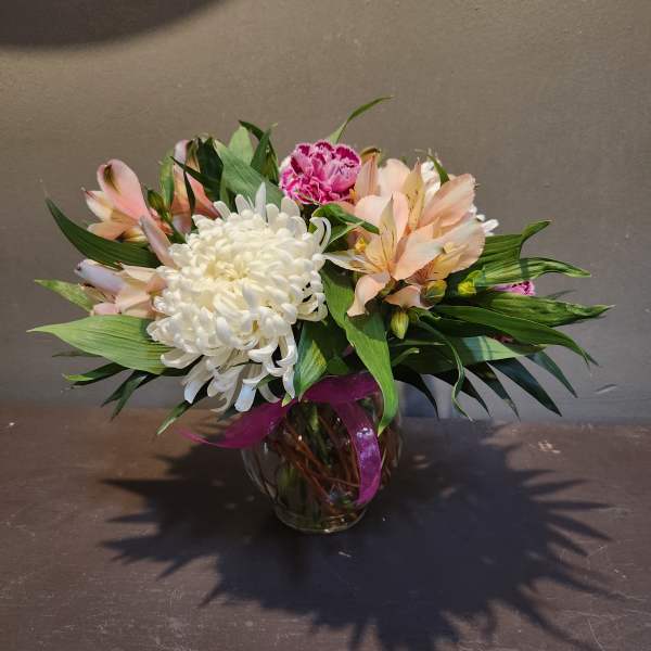 Bouquet of white and peach flowers in a glass vase