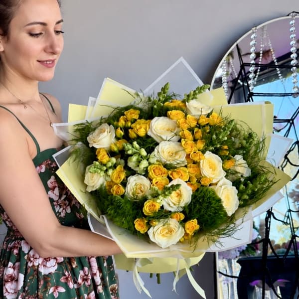 Woman holding a bouquet of white and yellow roses