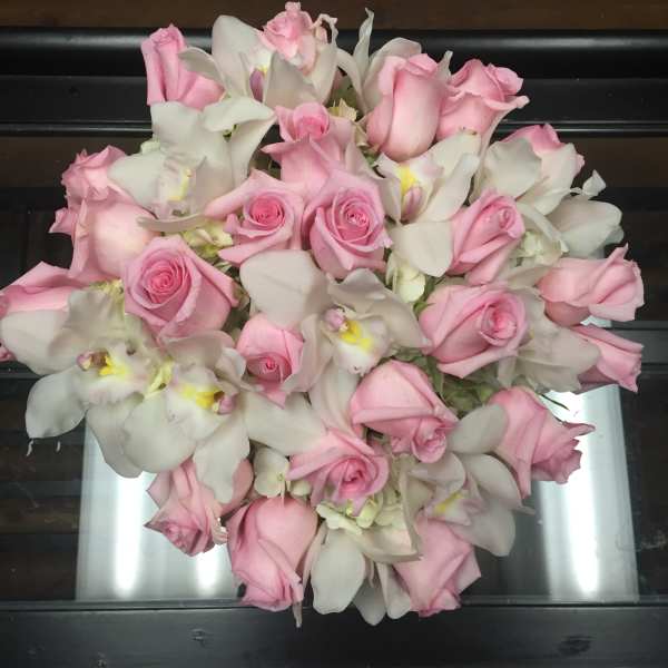 Pink roses and white orchids arranged in a bouquet
