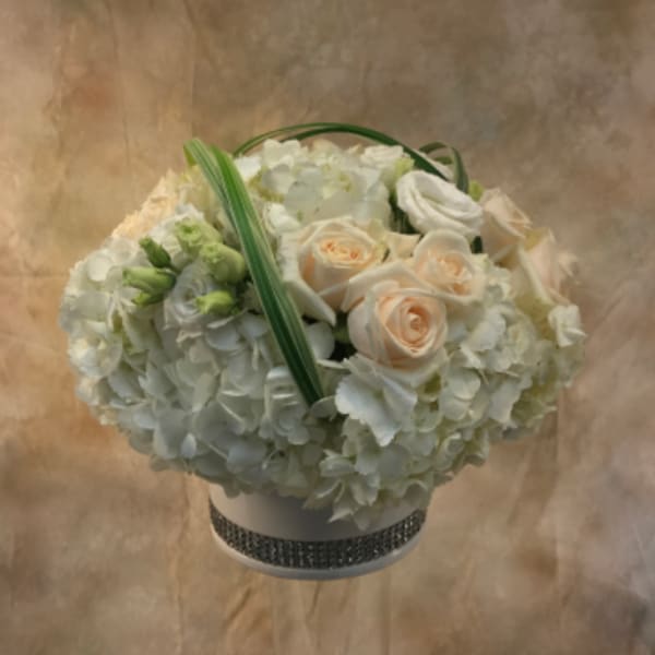 White and blush rose bouquet with hydrangeas in a decorated hatbox