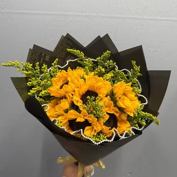 Bouquet of yellow sunflowers wrapped in black paper
