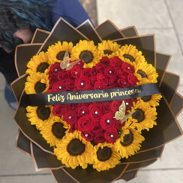 Heart-shaped bouquet of red roses and yellow sunflowers with a ribbon