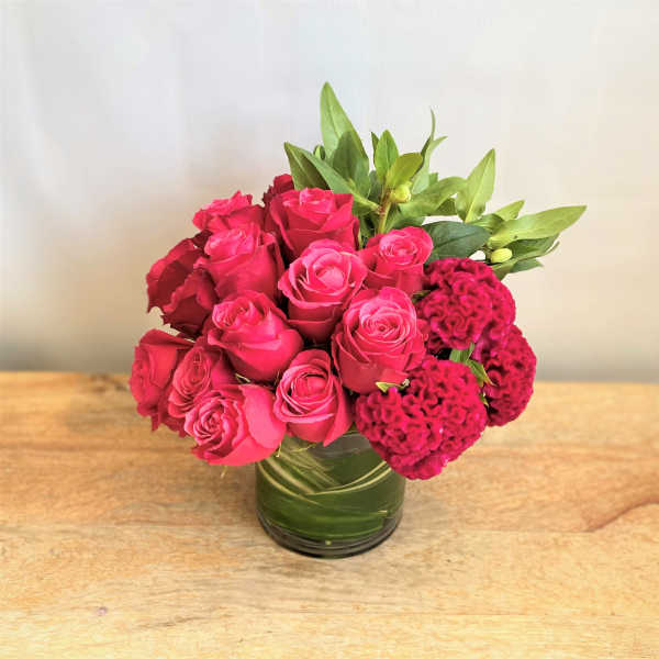 Pink roses and magenta cockscomb in a glass vase