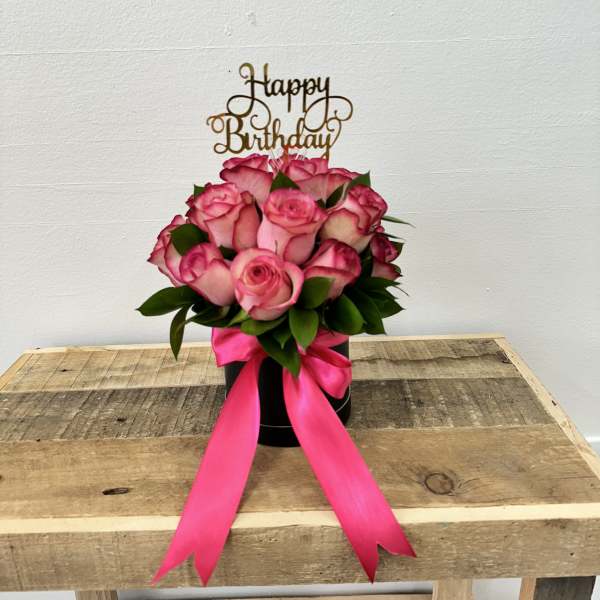 Pink rose bouquet in a black box with a birthday topper and ribbon
