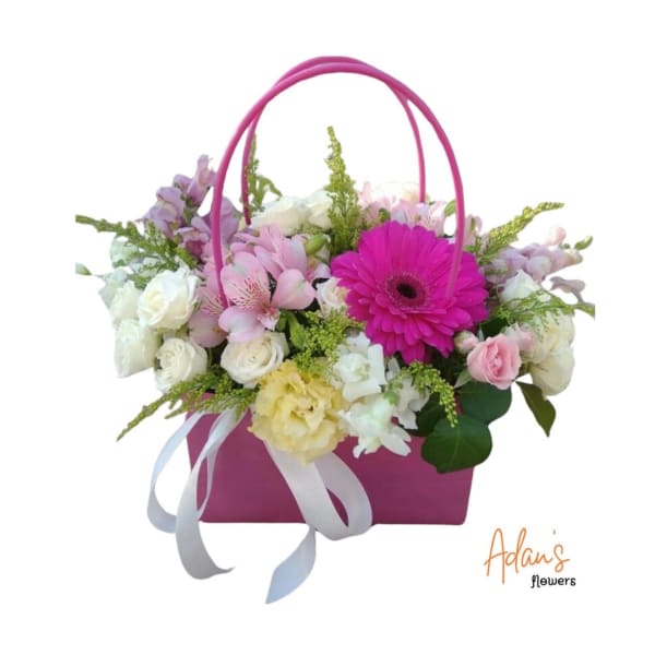 Pink basket arrangement with mixed pastel flowers and a ribbon bow