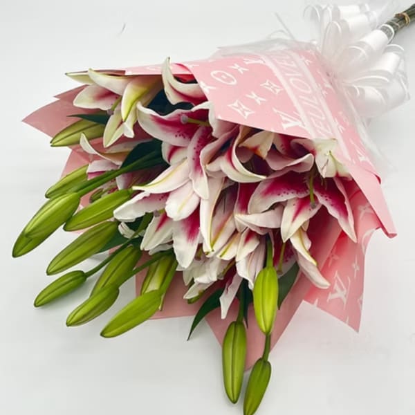 Bouquet of pink-and-white lilies wrapped in pink paper