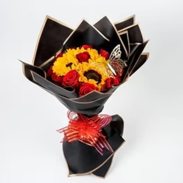 Bouquet of red roses and yellow sunflowers wrapped in black paper with a red ribbon