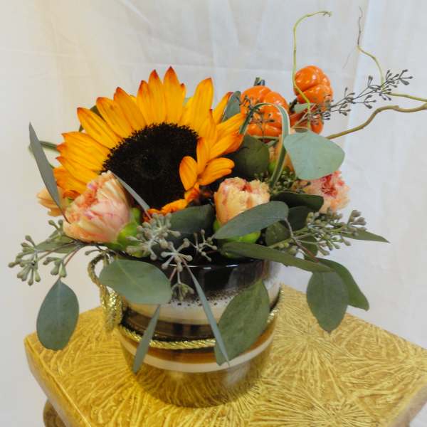 Sunflower arrangement in a black-and-gold vase with orange accents