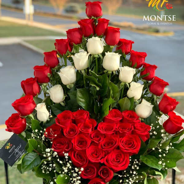 Heart-shaped arrangement of red and white roses in a basket