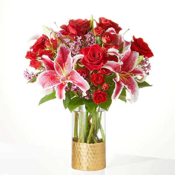 Red roses and pink lilies arranged in a glass vase