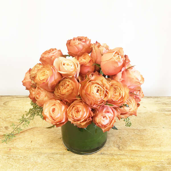 Peach roses arranged in a green vase