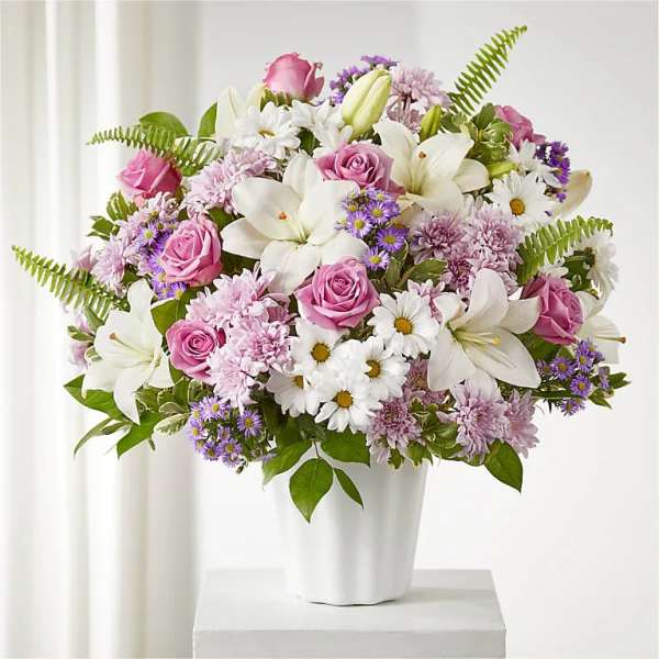 Pink roses and white lilies in a white vase