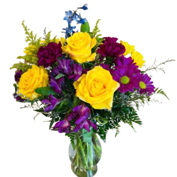 Bouquet of yellow roses and purple flowers in a glass vase