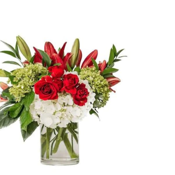 Bouquet of red roses, white hydrangeas, and lilies in a clear glass vase